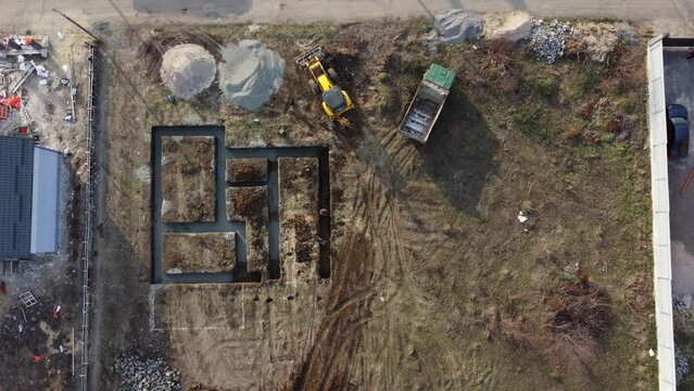 Aerial drone top down view on construction site with reinforced concrete house foundation, Digging a trench for the foundation.