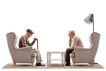 Sad elderly man and woman sitting in armchairs