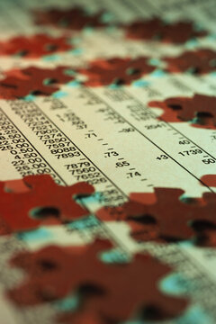 Close-up of jigsaw puzzle pieces on stock listings