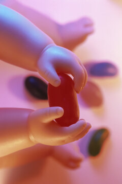 Close-up of a doll's hand holding a jelly bean