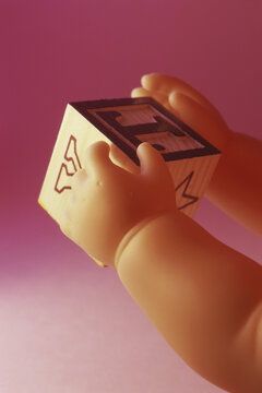 Doll hands holding building blocks