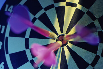 Close-up of three darts in the bull's-eye of a dartboard