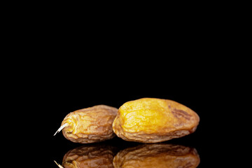 Two sweet dry dates, close-up, isolated on a black background.