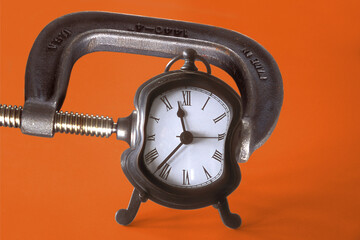 Close-up of an clamp squeezing an alarm clock