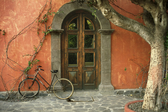Bicycle parked in front of a door, Posada de las Flores Hotel, Loreto, Mexico