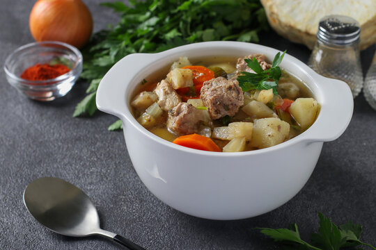Pichelsteiner, German stew or thick soup with meat and vegetables in white bowl, Close-up