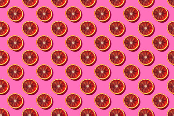 Seamless fruit pattern with round blood orange slices on a bright pink background, pop art style of the sixties