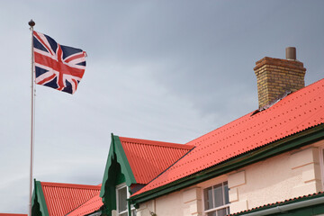 Low angle view of a British flag fluttering on the roof of a building, Stanley, Falkland Islands, England