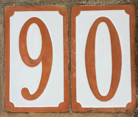 Number 90 in white and orange, with orange borders