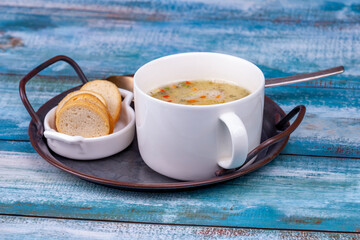 Pea soup puree in a large white cup on a vintage tray