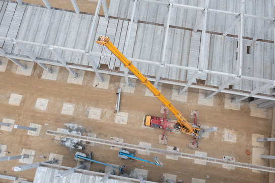 Factory Building. Aerial Industrial Construction Site with Crane and Construction Equipment.