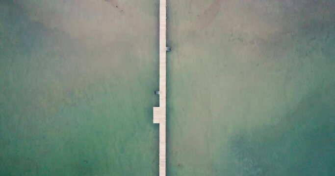 4K aerial top down footage of a wooden deck surrounded by a blue lake in Seeon-Seebruck with alps in background and birds in Bavaria, Germany
