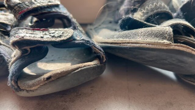 Close-up shot of an old worn children's sandals stand in a row