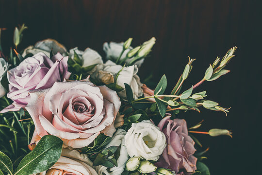 Dramatic Black Background with Romantic Wedding Bouquet with Roses in White and Pink with Gorgeous Deep Green Leaves