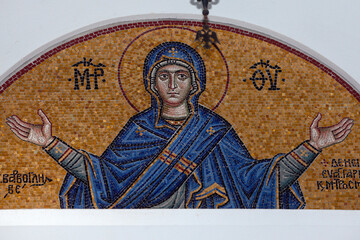 Colourful mosaic hagiography of Mother of God ,on the facade above the entrance of a greek church