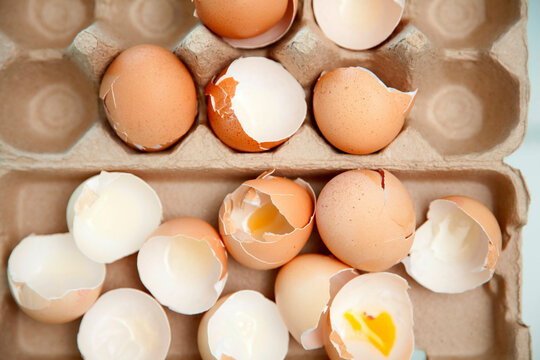 Broken eggshells in a carton