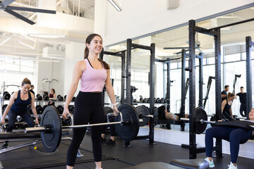 Young woman smiling with great pride, weight lifting.