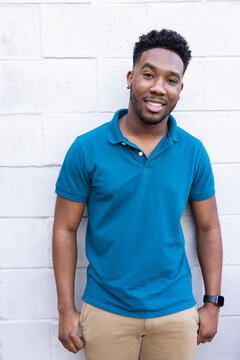 Portrait of a confident black man against white wall.