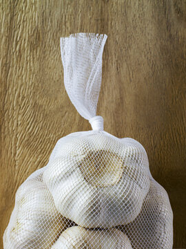 Close up of bulbs of garlic in net bag