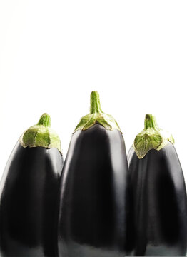 Close up of freshly picked aubergines against clear background