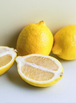 Close up of whole lemons and one cut in half on clear background
