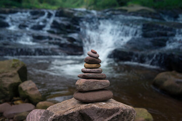 Piedras en equilibrio zen con cascada al fondo