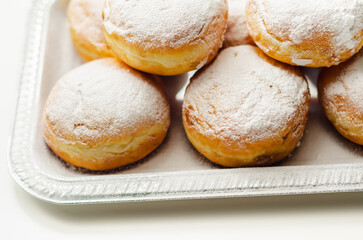 Berliner Pfannkuchen, a German donut, traditional yeast dough deep fried filled with chocolate cream and sprinkled with powdered sugar