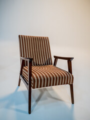 Stylish retro striped armchair with armrests on a white cyclorama