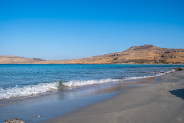 Fototapeta na wymiar Empty sandy rocky beach, Greece. Elafonisos, island. Sea water turquoise color, sunny summer day