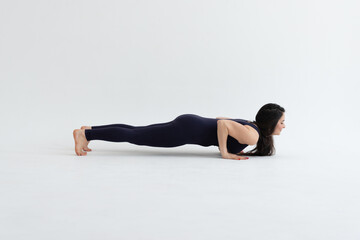 Fototapeta premium Healthy woman practicing relaxation yoga on a white background. making yoga exercises at studio. 