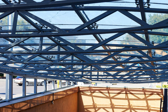 metal trusses of a glass canopy over the entrance to the metro station