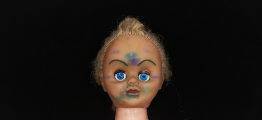 Scary, evil, spooky, demonic and possessed killer baby child girl doll head with creepy face and...