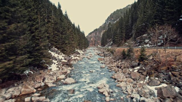 Drone Flyover Low Above River In Snowy Forest Near Latefossen Waterfall Norway