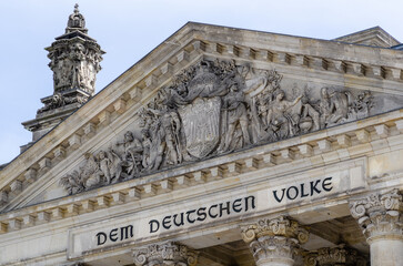 Fototapeta premium The Reichstag building (Bundestag) in Berlin, Germany, meeting place of the German parliament: The inscription says: Dem Deutschen Volke - To the German people