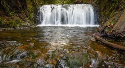 Beautiful mountain rainforest waterfall with fast flowing water and rocks, long exposure.