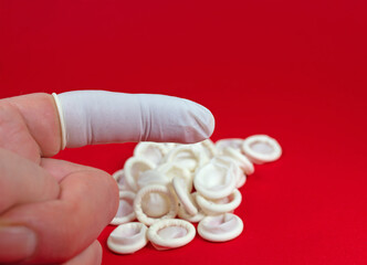 Fingerling  aus Latex vor rotem Hintergrund