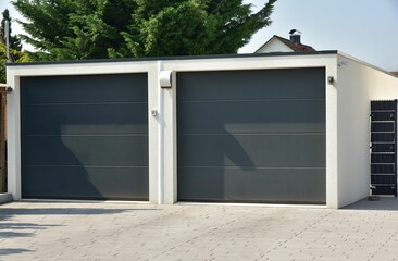 Moderne Beton-Garage mit Automatik-Tor in der Hauszufahrt