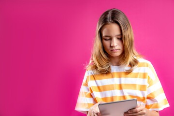 The girl watches the video on the tablet. The concept of youth dependence on gadgets, the spread of...