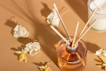 reed diffuser with flowers. Incense sticks for the home with a floral scent with hard shadows. The concept of eco-friendly fragrance for the home - obrazy, fototapety, plakaty