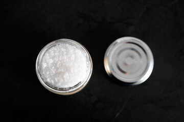 Large salt crystals in a glass jar on the kitchen table, top view