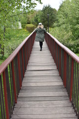 a girl walking on a bridge in a green raincoat