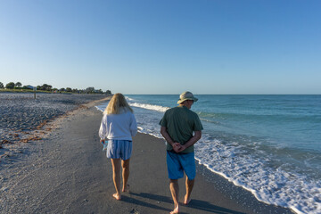 Old retired couple hunt for shark teeth on beach in Florida