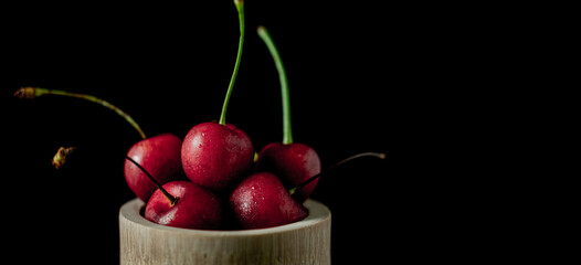 Popsicle with fresh cherries on a dark background, dynamic shot with action, splash, water drops and bokeh. Fresh fruit floating or levitating shotwith water droplet