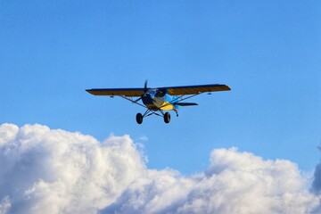 Fototapeta na wymiar yellow aiplane on the clouds