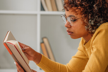 girl at home relaxed reading a textbook