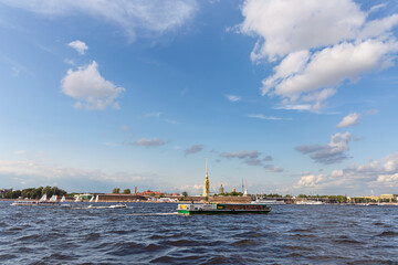 Obraz premium view of the Neva River in St. Petersburg and tourist ships against the backdrop of the ancient Peter and Paul Fortress and the blue sky