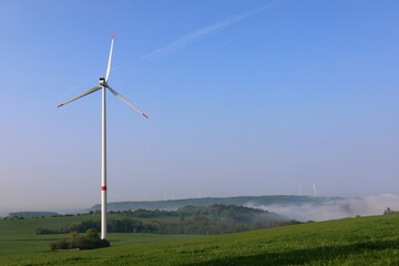 Fototapeta premium wind turbine on a field with fog