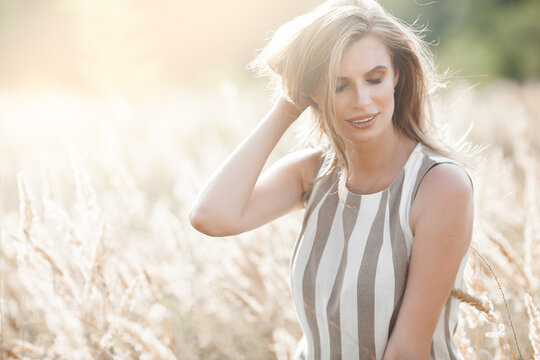 Beautiful blond woman closeup portrait outdoors. Smiling face. Lovely lady at summer background. Emotional female outdoors.