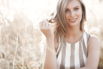Beautiful blond woman closeup portrait outdoors. Smiling face. Lovely lady at summer background. Emotional female outdoors.