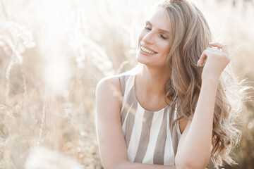 Beautiful blond woman closeup portrait outdoors. Smiling face. Lovely lady at summer background. Emotional female outdoors.